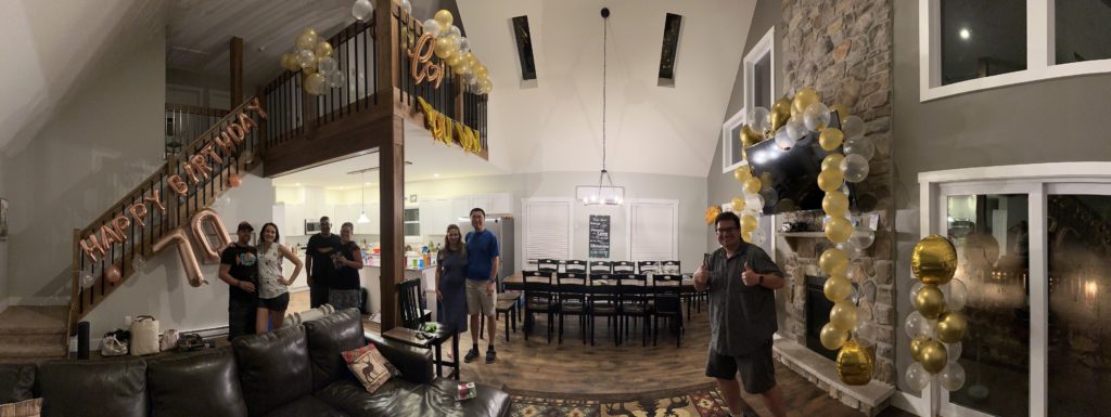 An image of the main floor of our vacation rental, with balloons that read "Happy Birthday 70", "Love You Wow", and other balloons draped over the television on the wall.